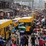 Danfo buses and traders crowd a busy Lagos market street
