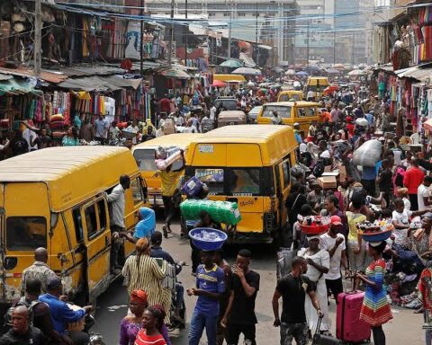 Danfo buses and traders crowd a busy Lagos market street