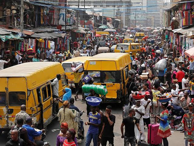 Danfo buses and traders crowd a busy Lagos market street