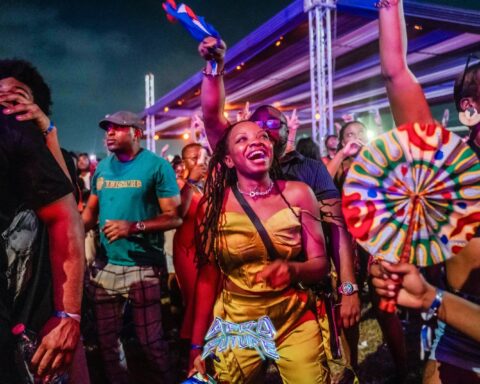Crowd of festival-goers dancing at night at an Afro Future event