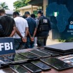 Illustration of FBI agents with seized devices for the Operation Blackout scam centre crackdown in Nigeria